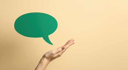 Female hand gesturing with green speech bubble on beige background
