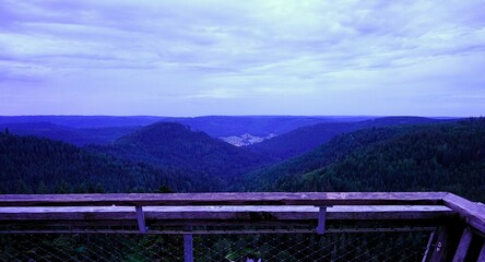Fototapeta premium Wooden observation deck with panoramic view over the Ellbachsee lake in the northern Black Forest near Freudenstadt in Germany at dusk, Ellbachseeblick
