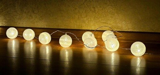 Decorative string lights create a warm ambiance along a wooden floor in a cozy indoor setting