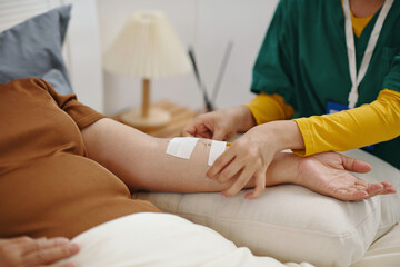 Close-up of nurse putting intravenous iv drip to senior woman in bed