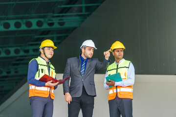 Construction project meeting with workers discussing plans in a modern facility during daylight hours