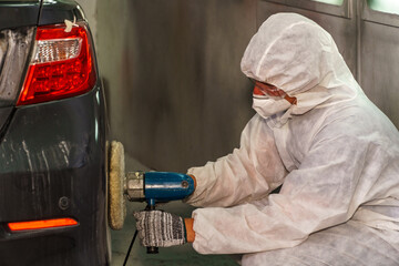 Detailing a car with precision using a polishing tool in an indoor garage