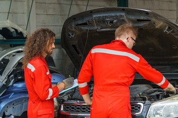 Mechanics working on a car in an automotive repair shop during daytime
