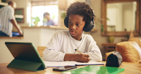 Naklejka premium Video, online and child with headphones, tablet and boy with information, education and studying for exam. Desk, growth and development of kid, listening and podcast for knowledge, African and home