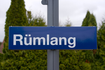 Blue and white metal sign at railway station of village of Rümlang on an autumn day. Photo taken...