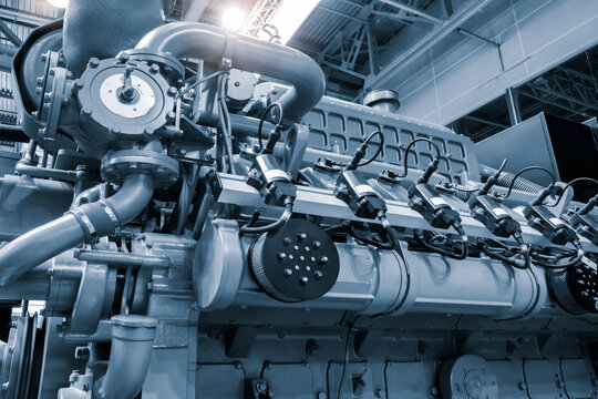 Big gas engine diesel generator electric power with many wires pipes industrial machine concept background
