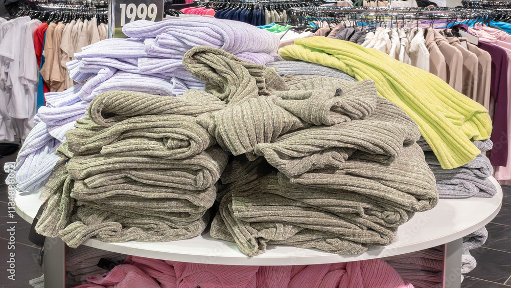 Poster a rack of clothes with a sign that says 1999. there are many different colors of clothes on the rack