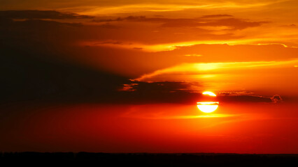 Dramatic red sunrise on dark cloudy sky