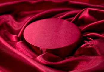 Silk satin round stage, elegant background. Red podium, product promotion backdrop.Textile...