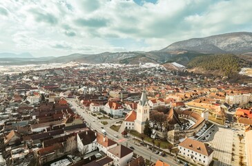 Discover a magnificent aerial perspective showcasing the stunning landscapes of Piatra Craiului, Rasnov, and Plaiul Foii. Snow-capped mountains and charming architecture create an enchanting view