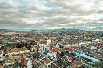 An expansive aerial view captures the charm of Rasnov and the majestic Piatra Craiului mountains....