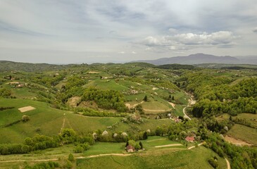 Explore the stunning natural beauty of Piatra Craiului, highlighting vibrant green hills and charming homes nestled in the serene countryside near Rasnov, Brasov on a sunny day