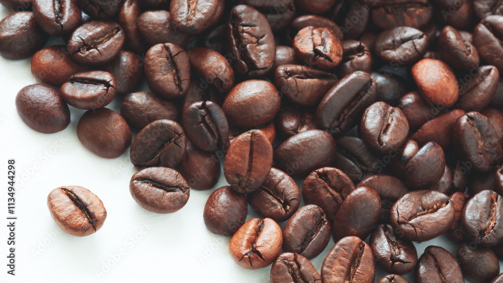 Poster A pile of coffee beans on a white background. The beans are of different sizes and shapes. Some are small and round, while others are larger and more elongated