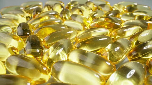 Omega 3 fish oil pills. Fish oil is essential supplement for wellness. Gold fish oil capsules. Slider dolly shot. Probe lens shot. Healthy lifestyle concept. Medical product
