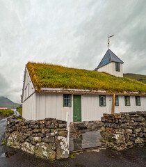 Church of Oyndafjørður with Grass Rooftop in Eysturoy, Faroe Islands. A weather vane is perched...