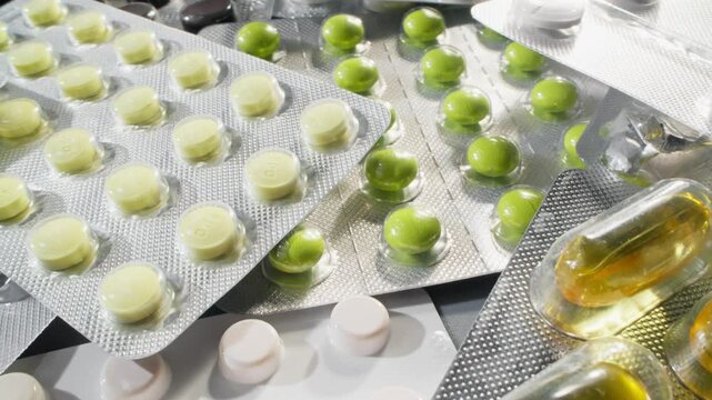 Concept of healthcare industry. Variety of pharmaceutical pills and capsules in different shapes, sizes, and color. Camera slide over tablets with macro lens. Pills blister pack. Dolly shot. 4K, UHD