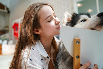 Girl with her dog, and puppy, smiling and holding her pets, showing love and happiness