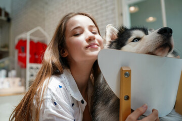 Woman with a dog smiling together with pets, showing love and happiness