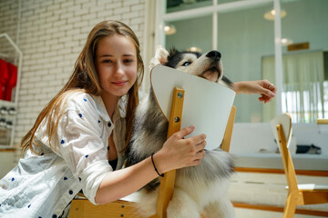 Smiling woman with her Siberian Husky puppy enjoying outdoor friendship and love