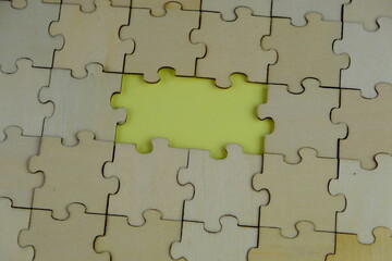 Fototapeta premium white jigsaw puzzle with missing puzzle for a text template. Above photo of isolated on the yellow background