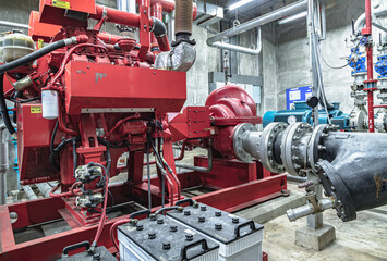 Obraz premium Fire protection system of Condominium. Red generator pump for water sprinkler piping and Fire alarm control system, Electric fire pump and Diesel fire pump for Fire fighting system, Copy space.