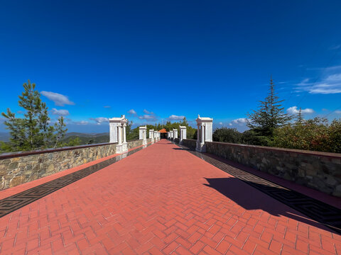 The path from Kykkos Monastery to the chapel on Throni Hill in the Troodos Mountains in Cyprus with a fence containing a number of mini-chapels with mosaics, icons of saints