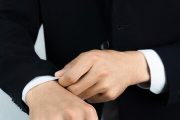 Obraz premium Close-up of a man in a tux fixing his cufflink and make a groom.
