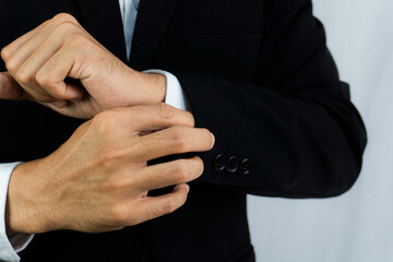 Obraz premium Close-up of a man in a tux fixing his cufflink and make a groom.