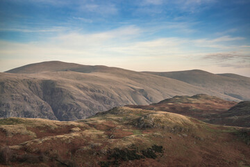 Lovely Autumn sunset landscape image looking towards Great Dodd from Castlerigg Stone Circle with soft pastel light