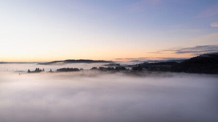 Naklejka premium Beautiful atmospheric aerial drone landscape image of cloud inversion in Loughrigg valley in Lake District during Autumn