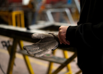 male welding worker putting on protective gloves