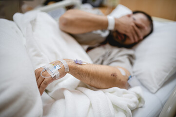 "Middle-Aged Man Resting Alone in a Hospital Room, Receiving IV Fluids and Medical Care