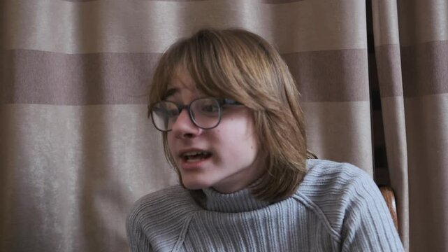 Young man with glasses speaks in slow motion, showcasing authentic expression and engaging communication in a casual setting