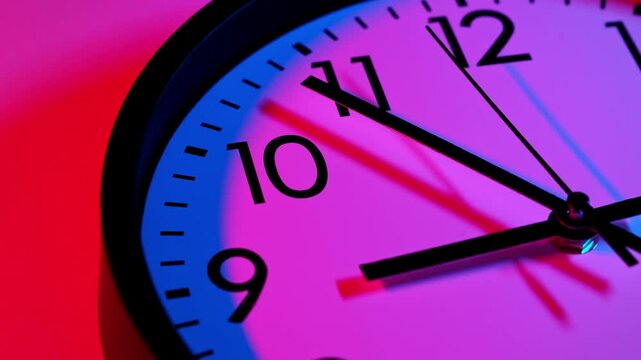 Wall clock show running time. Time lapse. Clock face on blue and red background. Zoom out of clock face. Time ticking on classic wall clock. Time concept. Close-up in 4K, UHD