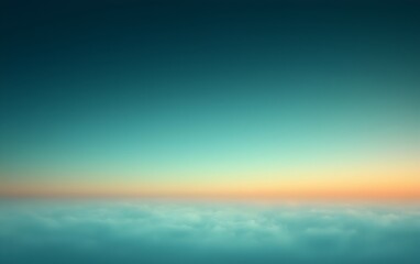 Obraz premium A serene gradient of colors in the sky at dawn, fading from deep turquoise to soft orange above a blanket of clouds, creating a tranquil and dreamy atmosphere.