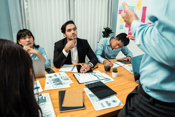 Diverse group of business analyst team analyzing financial data report paper on office table. Chart and graph dashboard by business intelligence analysis for strategic marketing planning Habiliment