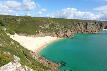 Sandy Porthcurno Beach, with Logan Rock headland, West Cornwall, UK.