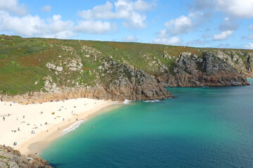Sandy Porthcurno Beach, with Logan Rock headland, West Cornwall, UK.