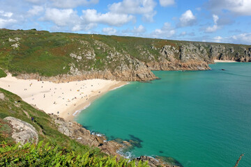 Sandy Porthcurno Beach, with Logan Rock headland, West Cornwall, UK.