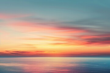 Obraz premium Beautiful sunset over the ocean with a few clouds in the sky