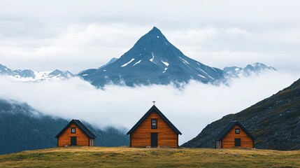 Scenic mountain landscape featuring three wooden cabins surrounded by mist and snow-capped peaks, evoking tranquility and natural beauty.