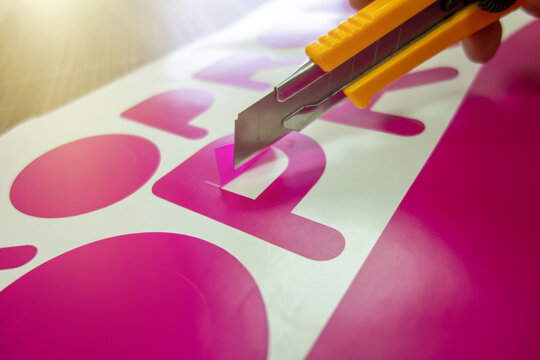 Plotter cutting of letters.The technology of precise cutting of contour images, logos, texts and shapes from self-adhesive film.A selection of vinyl film.