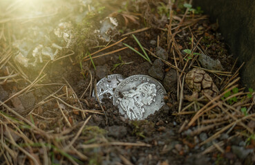 An antique silver coin with a picture of a person's profile.Find a treasure in the ground.The...