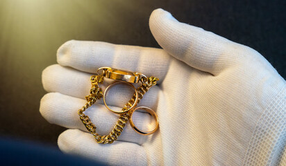 Purchase of gold jewelry.A white-gloved hand holds jewelry rings.Pawnshop.