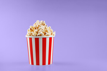 Classic red striped popcorn cardboard cup on Purple, violet background