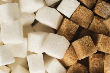 Cubes of unrefined brown demerara sugar and white refined beet sugar.