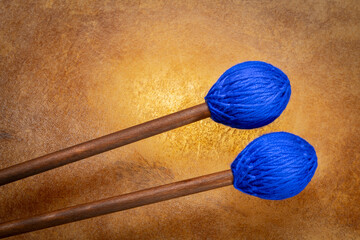 marimba mallets against backlit drum goat skin
