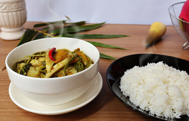 Bamboo shoot curry with hot steamed rice Placed together on a wooden table with a white background.

ไอคอนยืนยันโดยชุมชน