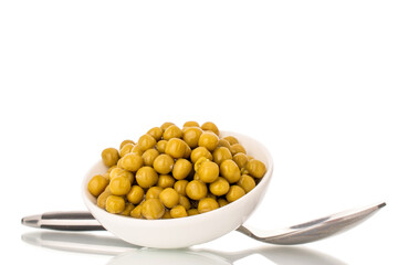 Canned green peas in a white ceramic dish, close-up, isolated on a white background.