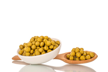 Canned green peas in a white ceramic dish, close-up, isolated on a white background.